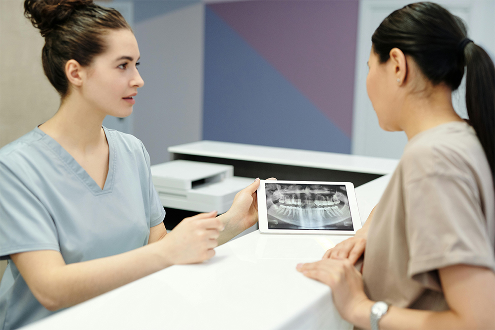Dentist reviewing a dental X-ray with a patient during a consultation